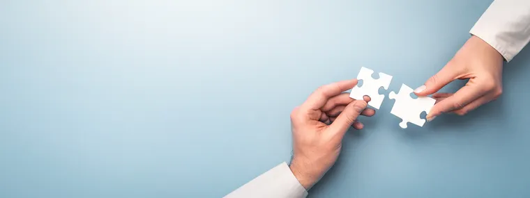Hände mit Puzzleteilen
